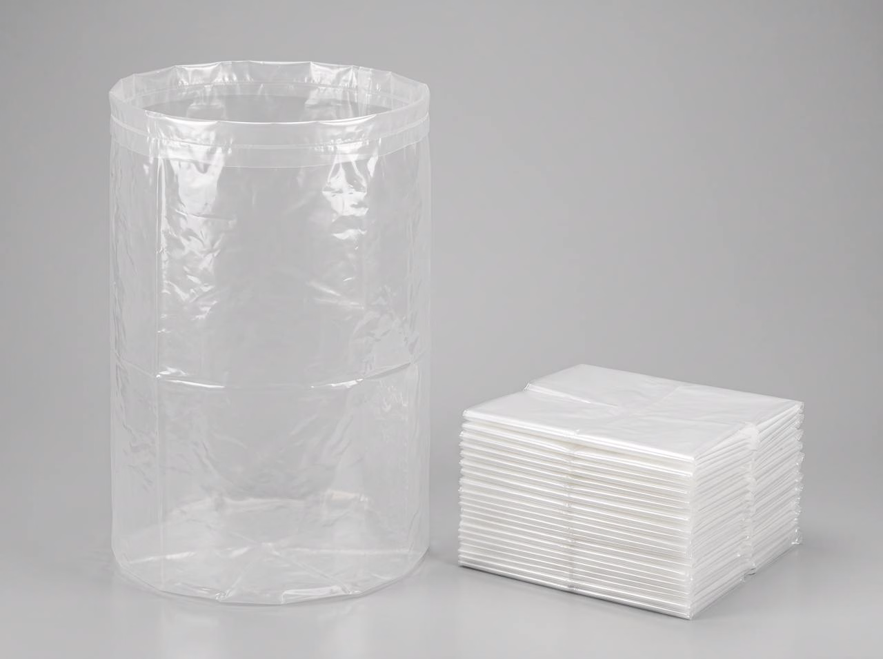 Clear 6 mil plastic dust collector collection bags, one open and a stack of folded bags